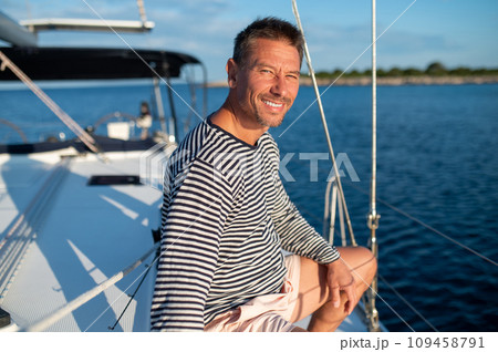 Man in a striped shirt sailing on a yacht 109458791