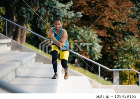 Good-looking dark-skinned athlete exercising on the stairs 109459168