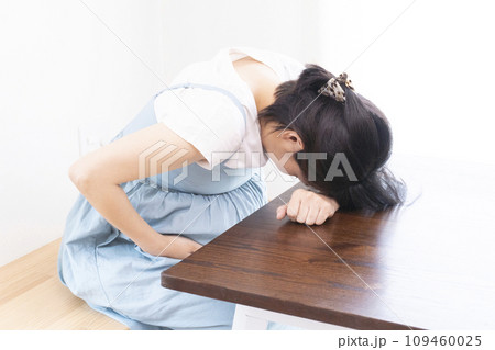 体調が悪そうに机に突っ伏す臨月の妊婦女性 体調が悪そうに机に突っ伏す臨月の妊婦女性 109460025