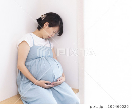 体調が悪そうな目を閉じてる臨月の妊婦女性 体調が悪そうな目を閉じてる臨月の妊婦女性 109460026