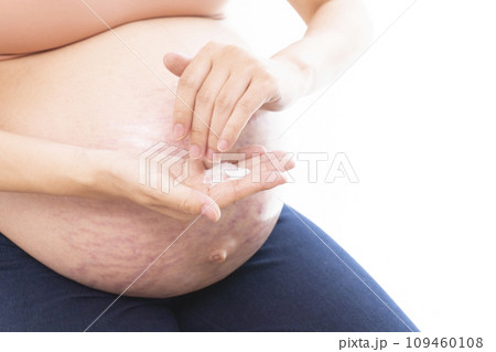 妊娠線ができたお腹にクリームを塗る女性の手と臨月のお腹 妊娠線ができたお腹にクリームを塗る女性の手と臨月のお腹 109460108