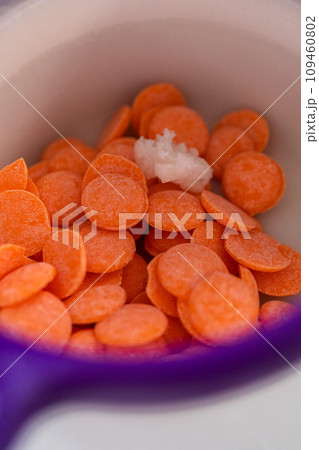 Melting chocolate chips in a candy melting pot to make chocolate carrot cake toppers. Melting chocolate chips in a candy melting pot to make chocolate carrot cake toppers. 109460802