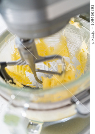 Mixing ingredients in kitchen electric mixer to bake panda-shaped shortbread cookies with chocolate icing. 109460893