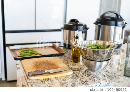 Watch as fresh green beans are beautifully roasted to perfection on a baking sheet with a silicone mat, adding a burst of flavor to your meal. 109460925