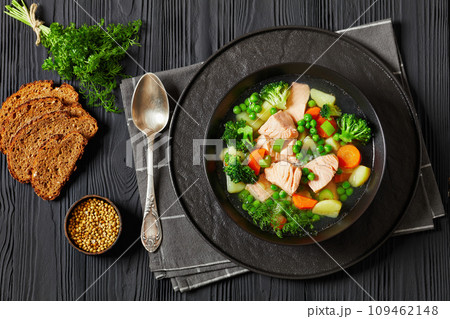 salmon, veggies and green herbs soup in bowl salmon, veggies and green herbs soup in bowl 109462148