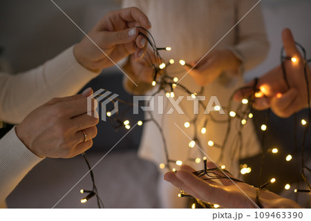 A family is unraveling a New Year's Christmas garland. 109463390