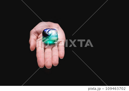Washing capsules in hands. Washing powders for washing clothes in a washing machine, on a black background. Purity concept Washing capsules in hands. Washing powders for washing clothes in a washing machine, on a black background. Purity concept 109463702