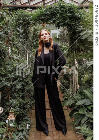 A woman walking through a greenhouse. A woman walking through a greenhouse. 109466622