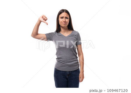 young positive brunette woman demonstrates a t-shirt with space for printing identities on a white young positive brunette woman demonstrates a t-shirt with space for printing identities on a white 109467120
