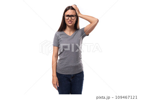 portrait of a caucasian slim young woman in glasses dressed in a gray basic t-shirt and jeans portrait of a caucasian slim young woman in glasses dressed in a gray basic t-shirt and jeans 109467121