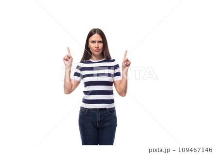 young european lady with black even hair dressed in a striped t-shirt points with her index finger 109467146
