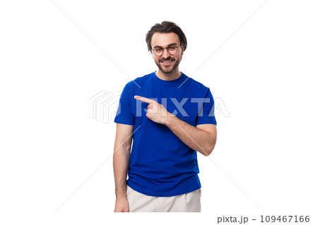 caucasian man with dark well-groomed hair and a beard in a blue t-shirt points his hand to the side 109467166