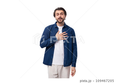 young handsome caucasian man with black hair is dressed in a blue shirt and light trousers on a 109467205