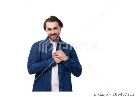portrait of a young handsome brutal brunette guy in a denim shirt on the background with copy space portrait of a young handsome brutal brunette guy in a denim shirt on the background with copy space 109467213