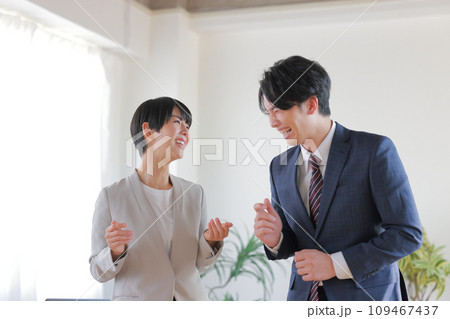 立って打ち合わせ_大笑いするビジネスマン1 109467437