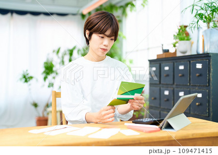 通帳を眺める若い女性 通帳を眺める若い女性 109471415