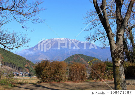 紅葉した山の奥に見える雪が積もった伊吹山と山腹に浮かぶ雲 青空の背景 紅葉した山の奥に見える雪が積もった伊吹山と山腹に浮かぶ雲 青空の背景 109471597