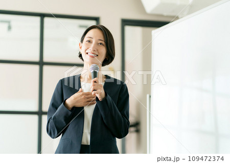 マイクを持って話すスーツの女性 109472374