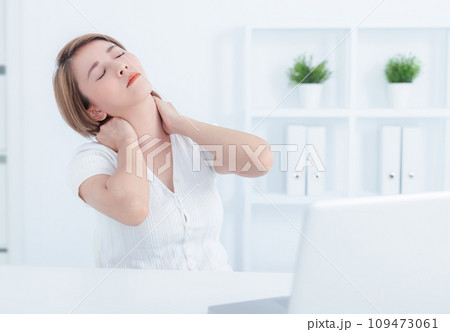 Young Asian woman suffering from neck pain in office Young Asian woman suffering from neck pain in office 109473061