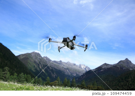 Flying drone in high altitude mountains 109474459