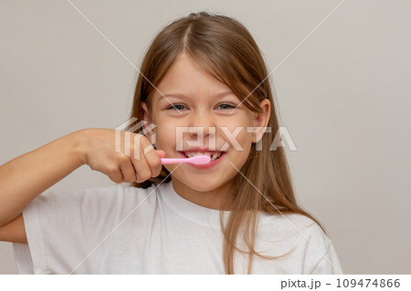 Portrait of caucasian happy little girl with open wide smile holding tooth brush near teeth looking at camera 109474866