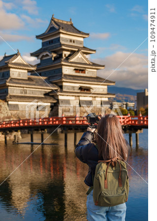 Woman tourist Visiting in Matsumoto, happy Traveler taking photo Matsumoto Castle or Crow castle. Landmark and popular for tourists attraction in Matsumoto, Nagano, Japan. Travel and Vacation concept 109474911