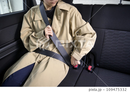 後部座席でシートベルトをする人物 109475332