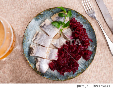 Lightly salted herring with beets served on platter 109475834