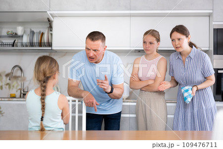 Parents and elder sister scold daughter in kitchen Parents and elder sister scold daughter in kitchen 109476711