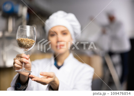 Female brewmaster holding glass of malt 109476854