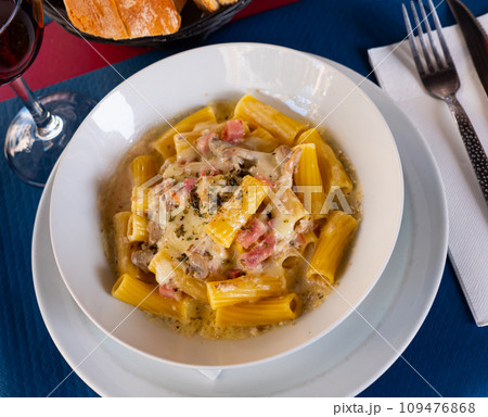 Tortiglioni pasta carbonara with cheese sauce and cured pork Tortiglioni pasta carbonara with cheese sauce and cured pork 109476868