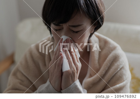 風邪を引いて鼻をかむ女性 風邪を引いて鼻をかむ女性 109476892