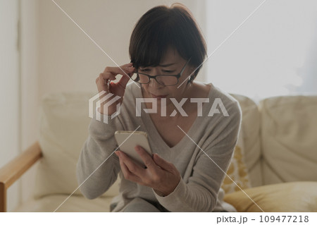 老眼でスマホが見えずらい女性 109477218