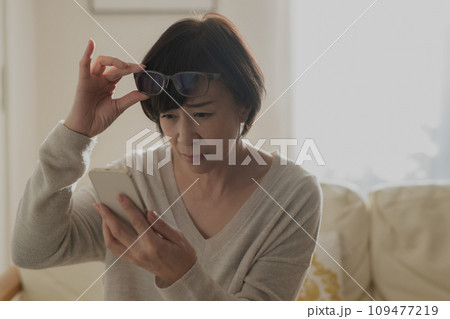 老眼でスマホが見えずらい女性 109477219