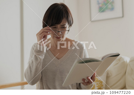 老眼で本が見えずらい女性 老眼で本が見えずらい女性 109477220