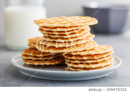 Round waffle biscuits on plate on kitchen table. 109478102