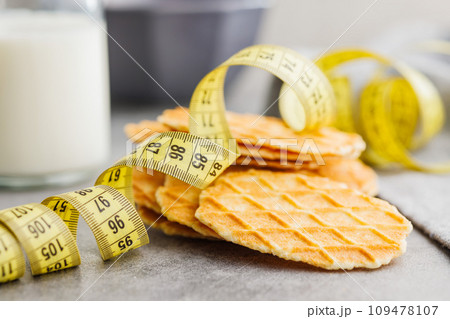 Round waffle biscuits and measuring tape on kitchen table. Round waffle biscuits and measuring tape on kitchen table. 109478107