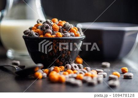 Sweet breakfast cereals in bowl on kitchen table. Sweet breakfast cereals in bowl on kitchen table. 109478128