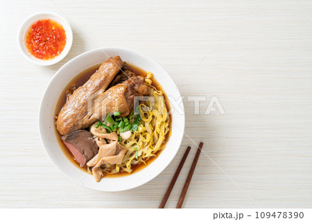 egg noodles with stewed and braised duck in brown soup 109478390
