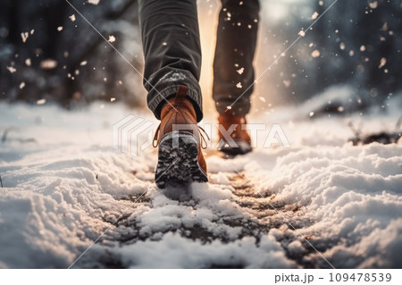 The feet of a man walking in the snow 109478539