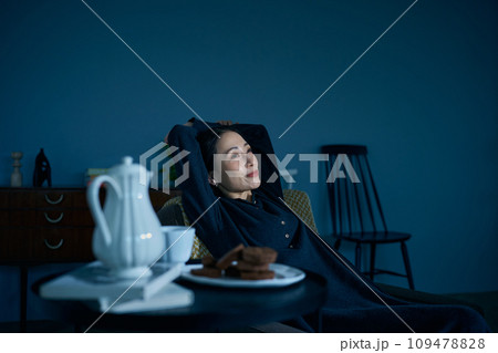 暗い部屋でくつろぐ女性 109478828