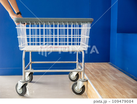 Laundry and housework. Woman hands holding empty new white trolley cart, metal cart parked use for laundry at convenience store for support customer, Laundromat convenience store concept 109479084