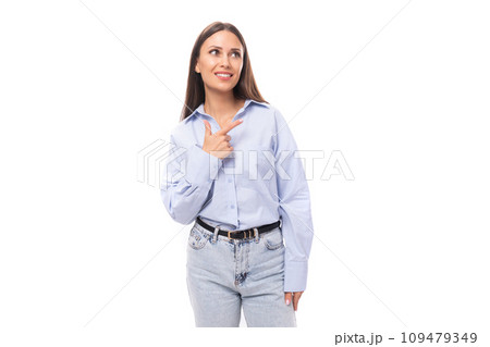 attractive young brunette caucasian woman dressed in a sky blue shirt looks attentively to the side attractive young brunette caucasian woman dressed in a sky blue shirt looks attentively to the side 109479349