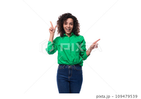 young caucasian brunette woman with curled hair dressed in a green shirt points her finger towards 109479539