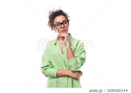 young stylish caucasian secretary woman with black curly hair in glasses and light green shirt on a young stylish caucasian secretary woman with black curly hair in glasses and light green shirt on a 109480144