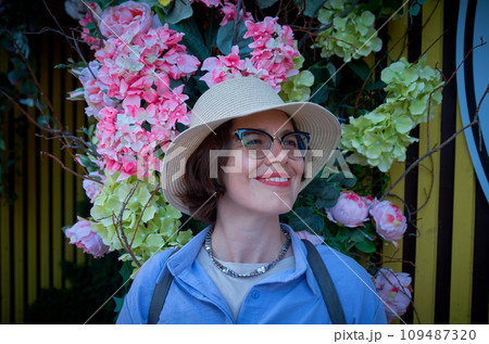 Portrait of a woman against a wall decorated with flowers Portrait of a woman against a wall decorated with flowers 109487320