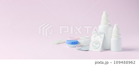 Contact lens, solution bottle and eye drops with box on light pink background, copy space Contact lens, solution bottle and eye drops with box on light pink background, copy space 109488962