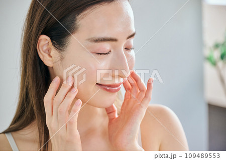 顔をマッサージして肌のお手入れをする30代女性 顔をマッサージして肌のお手入れをする30代女性 109489553
