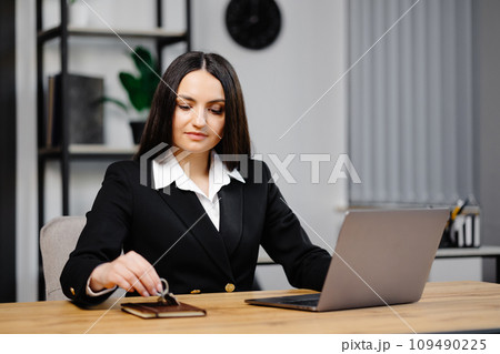Young happy employee business woman wearing suit sitting at office desk with laptop and giving key in office 109490225