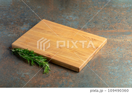 Cutting board and rosemary on a rusty iron table. Cutting board and rosemary on a rusty iron table. 109490360